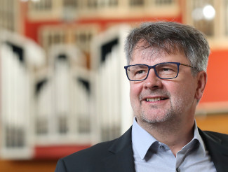 KMD Volker Gloßner vor der Orgel